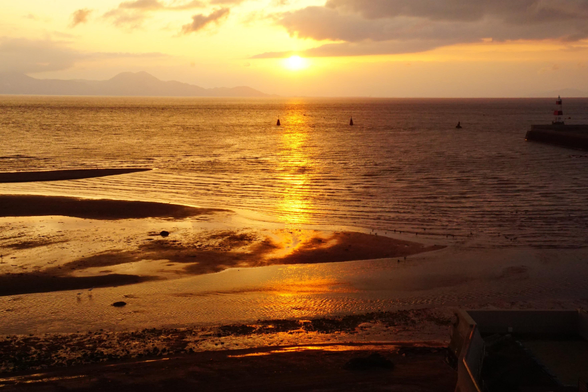 The setting sun casts the sea and coast in fabulous oranges.