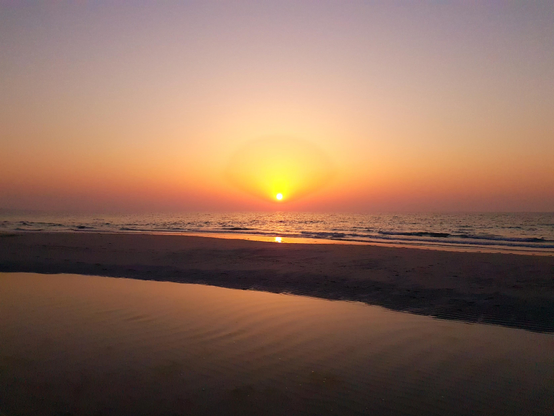 The setting sun casts the sea and coast in fabulous oranges.