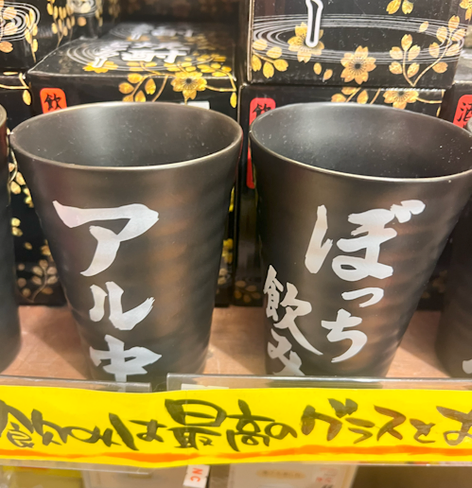 A set of metal drinking cups with the words “Alcoholism” and “Drinking Alone” is one of the…interesting products you can pick up at Village Vanguard.