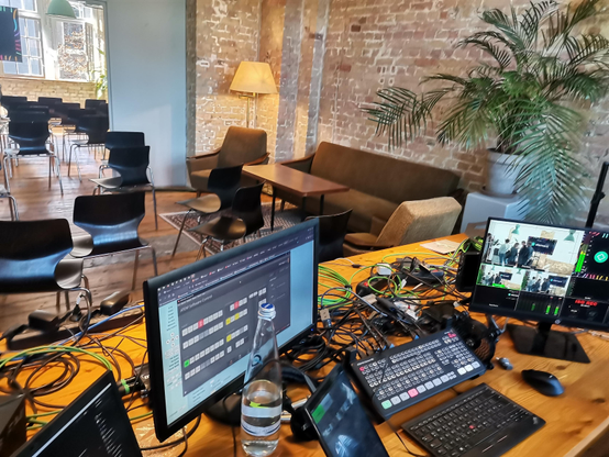 Ein Tisch auf dem diverse technische Endgeräte, Monitore, Atem für Livestreaming stehen.