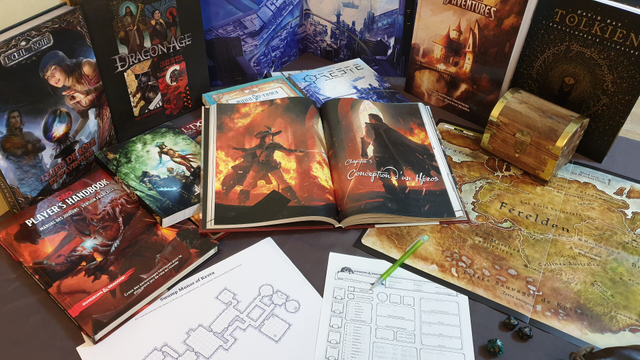A collection of TTRPG and fantasy books, like The Dark Eye, a Tolkien dictionary, DnD 5E player's handbook, etc. creatively set up on a table, with a dungeon map, a DnD character sheet and a map of Dragon Age Ferelden.