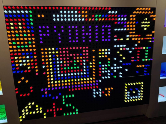 Photo of a lighted peg wall decorated in various patterns. PyOhio is spelled out in purple in the top center. Various other people's initials and smiley faces are scattered over the board.
Image credit: Photo from PyOhio 2025 by Mike Pirnat