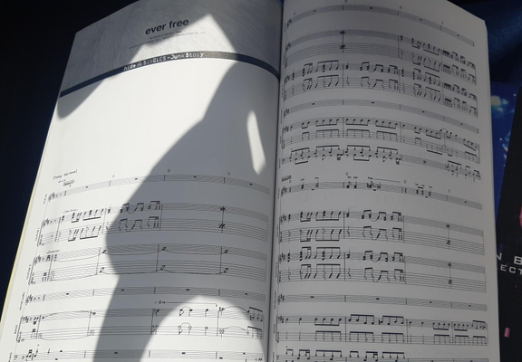 Photo of 2 pages from book of sheet music from Jrock Hide that says Hide Singles Junk Story