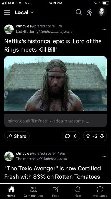 A screenshot of the Fediverse app showing the “Local” feed. The top post is from c/movies@piefed.social by LadyButterfly@piefed.blahaj.zone. The headline reads: “Netflix’s historical epic is ‘Lord of the Rings meets Kill Bill’.” Below it is an image of a shirtless, muscular man with long hair and a beard, his face streaked with blood, standing in front of thatched-roof huts. The post links to a Mirror UK article. Engagement shows 10 comments and a score of -2.

The second post is also from c/movies@piefed.social, posted by TheImpressiveX@piefed.social. It reads: “‘The Toxic Avenger’ is now Certified Fresh with 83% on Rotten Tomatoes.”

At the bottom, the app’s navigation bar is visible with icons for Home, Communities, Post, Inbox, and Messages. The status bar at the top shows “ROGERS 5G+,” the time as 5:19 PM, battery at 57%, and the user’s profile photo in the top-right corner.