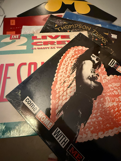 Stack of vintage vinyl records, 2 Live Crew, Thompson Twns, and Price’s Batdance on the background.