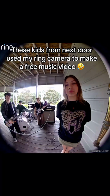 A Ring doorbell camera view shows a group of teenagers playing in a rock band on a porch. Three kids in the background are playing guitar and drums, while one girl stands at the front looking directly into the camera, wearing a black MTV T-shirt. Text on the video says: “These kids from next door used my ring camera to make a free music video 🤣.

Followed by the band plays their song, cutting from scene to scene, since they took various shots, in different times, both day time, and night time.
