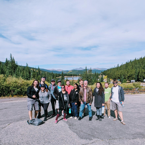 A group of over a dozen Linux people posing at Summit Lake on Mount Blue Sky in Colorado
