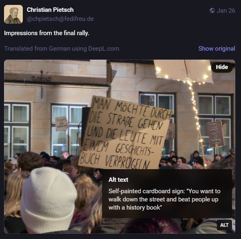 Screenshot of a post from Christian Pietsch which contains a close-up photo of a large protest rally crowd. One of the protesters is holding a handwritten cardboard sign that reads, in German:  "You want to walk down the street and beat people up with a history book". The author of the post adds: "Impressions from the final rally".

The post was originally in German, but was translated using the free DeepL.com service, and the alt text contains the translation of the protest sign.