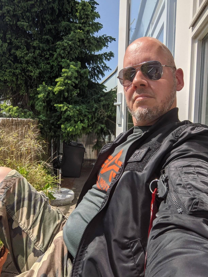 It's my on my balcony getting ready for the leather social. I am wearing my military outfit with Alpha industries Tee and Jacket and a cameo short. I am wearing an Aviator Ray-ban.