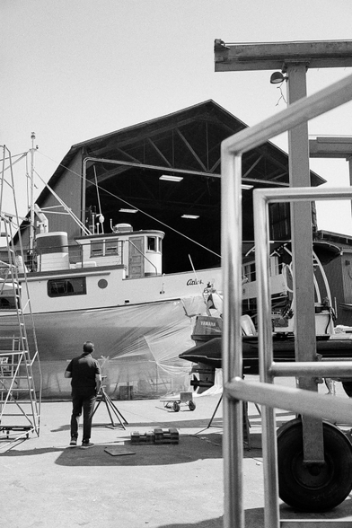 A man lost in thought in the boat yard.