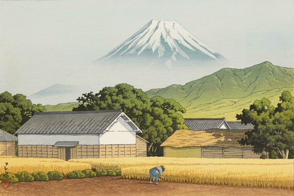 An autumn day on a rice farm somewhere in Hara, Japan. In the foreground, a lone farm worker stoops to tend to a field of golden rice. Just beyond, a group of farmhouses stands amongst tall trees; further on, low tree-covered mountains cross the horizon. In the distance, dominating the view, the snow-capped Mount Fuji rises into a hazy sky.