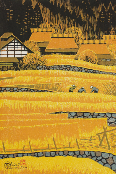 A bright autumn day on a farm in Ohara, near Kyoto, Japan. In the foreground, layers of farming terraces separated by stone retaining walls are filled with golden rice; the sheaves closest to us have been cut and hung to dry on racks, while just beyond, a trio of farm workers continues to harvest the crop. Further on, a group of buildings including traditional thatched-roof houses stands sheltered by a dark forest marching up the mountainside and out of view.