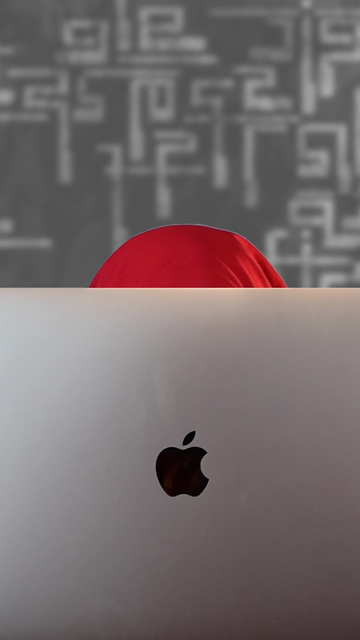 A video showing my face popping up from behind a laptop screen. The image then rotates to show what is on the screen: various behind the scenes snippets from a music video production, including images of the set and parts of my editing process. 