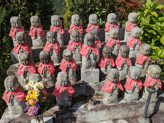 Small statues of Jizo, each with their own bib.