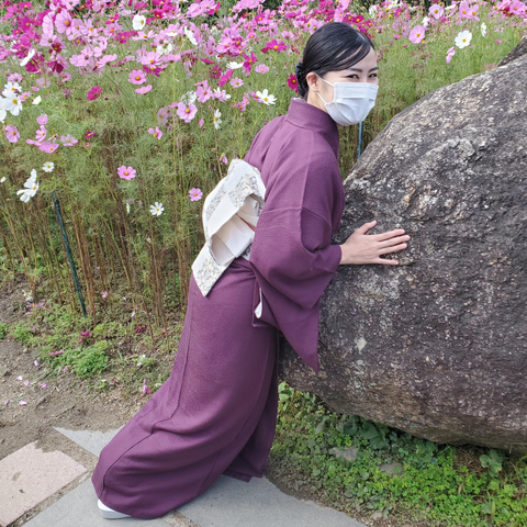 Nao-san pushes against a large rock in the grounds of Hannya-ji.