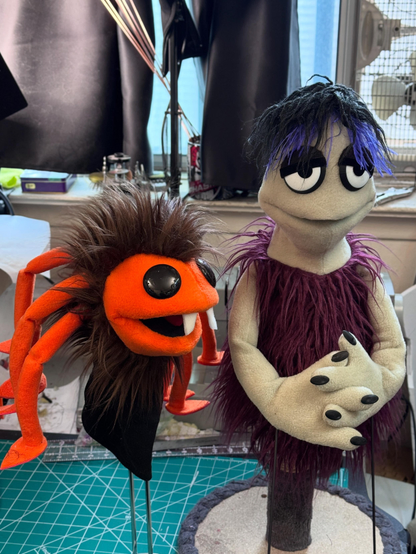 A spider hand puppet and a pointy head goth
