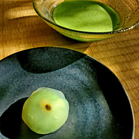 Kagijin's (かぎ甚) 'sawabe-no-hotaru' (沢辺の蛍) depicts a firefly flitting over a riverbank. The insect is cleverly made up of a single 'daitokuji nattō' (大徳寺納豆)🫘