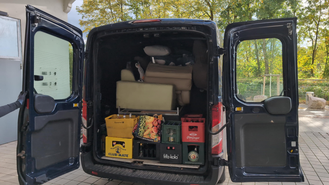 A transporter tetrissed with sofas, crates of beverages, sharks, pillows and random stuff.