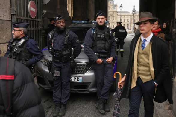 dapper old style man next to French police outside The Louvre
