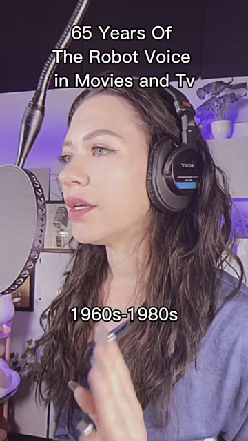 A woman stands in a recording studio, wearing headphones, and speaking into a microphone.