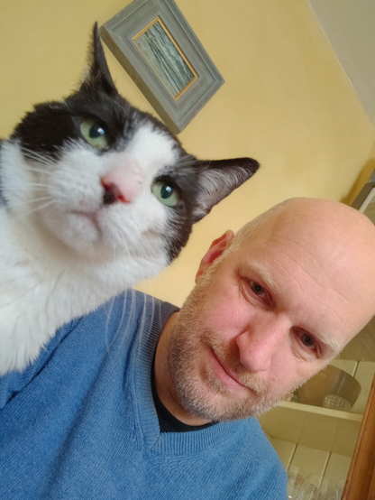 Selfie photo of Bob and his cat Molly. Molly is close to camera and looks annoyed at having her photo taken.