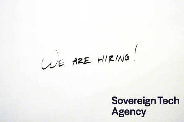 „We are hiring!“ steht auf einem Whiteboard, mit dem Logo der Sovereign Tech Agency unten rechts.