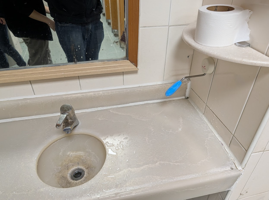 a piece of blue soap on a stainless steel rod which is mounted to the wall.