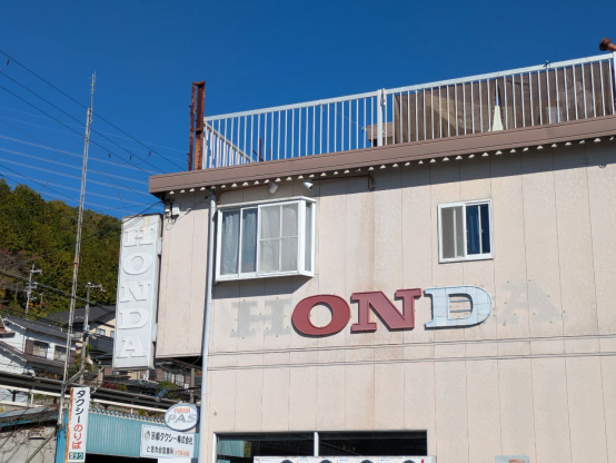 オートバイ店の"HONDA"の看板のHとAがなくなって"OND"になっている