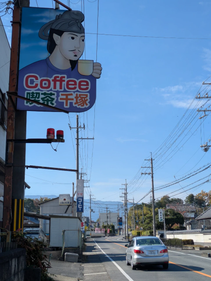 「喫茶千塚」の看板。聖徳太子っぽい人がコーヒーカップを手にしている。