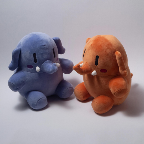 Zwei plushtodons sitzen sich gegenüber, einer in blau und einer in orange, auf einem weißen Hintergrund.