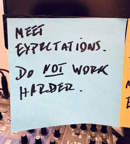 A post-it saying “meet expectations, do NOT work harder”