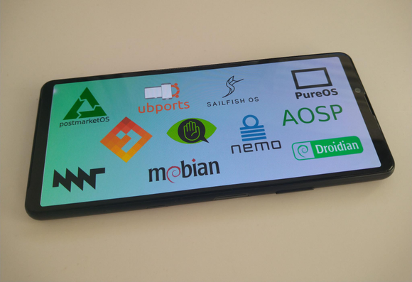 A mobile phone showing lots of logos on the screen: postmarketOS, MNT, AndroidOS, ubports, mobian, CalyxOS, NemoMobile, Sailfish OS, AOSP, PureOS and Droidian.