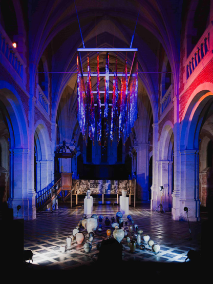 Une exposition dans une église, céramiques, dessin en fresque, éclairage de théâtre, lumieres dans la nef