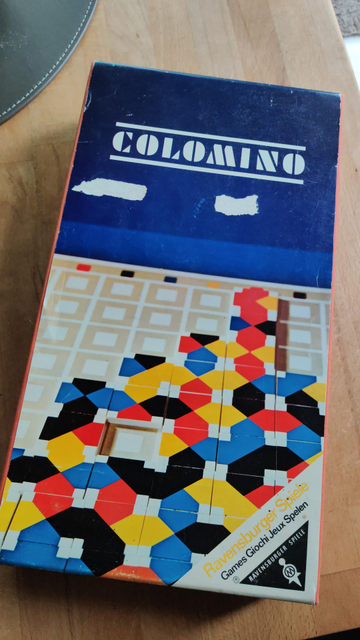Front box cover of the board game "Colomino" by German game company Ravensburger. The picture shows colored tiles on a board with squares.