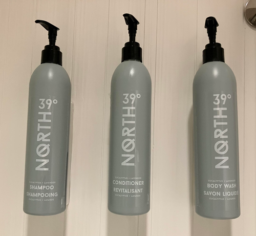 Hotel dispensers for shampoo, conditioner, and body wash. Now the print is a bright white on gray, and it's very legible. 