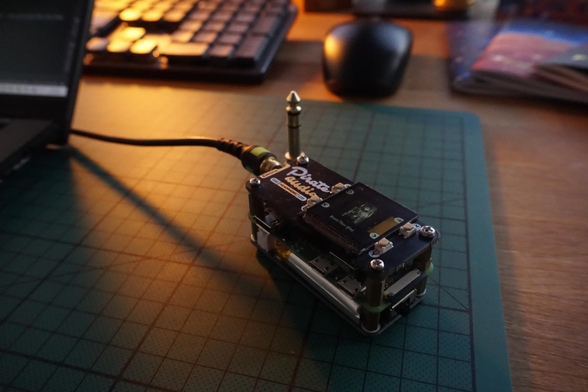 A picture of the MP3 Player, which consists of a stack of 3 PCBs, the lowest one is a HAT for the Pi Zero, that supplies power from a battery over pogo pins. In the centre there is the Pi Zero and above it the Pimori Pirate Audio Headphone DAC HAT. 