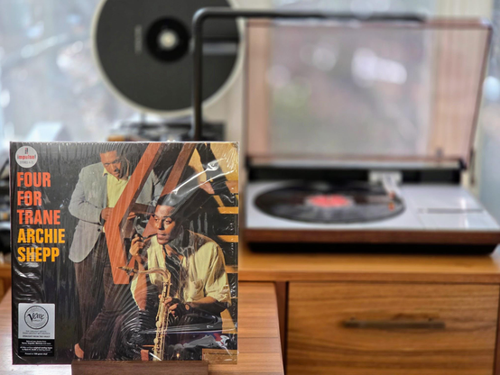 Archie Shepp - Four for Trane LP cover.

Shepp and, I'm guessing (sorry), Roswell Rudd , in a full-bleed shot looking pensive with instruments.

The black LP plays on a vintage, restored Bang & Olufsen Beogram 4000 linear-tracking turntable to the right.