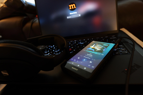 Sony Walkman sitting on keyboard of a Lenovo ThinkPad.