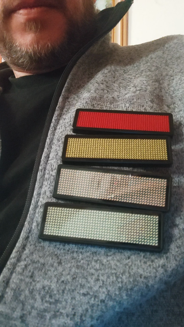 Video of 4 small LED badges below each other on my fleece jacket. The content has been timed carefully so that the number 2026 drops down from badge to badge