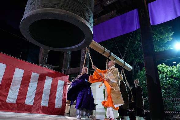 Monks strike a giant bell in celebration at the Zojoji Buddhist temple.