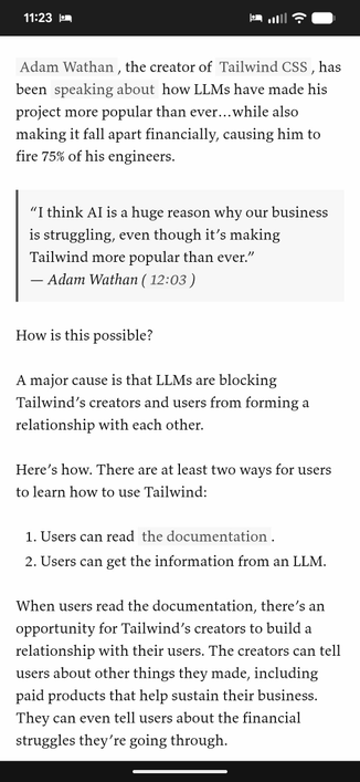 Black and white screenshot of a blog post about Tailwind (text irrelevant) on a phone at 11:23 PM with the bedtime mode icon visible at the top. There's paragraphs, a block quote and a numbered list. None of the text is underlined but there are incredibly subtle contrast changes on some words.