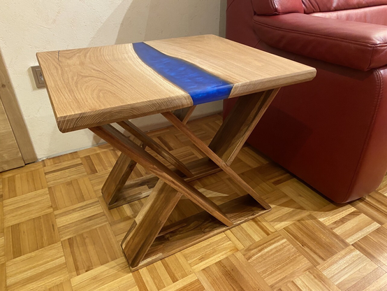 A epoxy resin river coffee table in a living room beside a red sofa