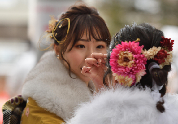 Two girls dressed up for Coming-of-Age Day (they are wearing stoles as January is bitterly cold in Japan).