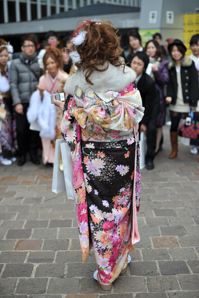 A young woman poses for photos on Coming-of-Age Day (although many men choose suits over kimono, almost all women will wear a traditional furisode).