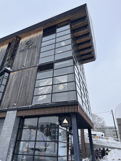 The Odin Centre in Grand Hirafu. It’s a modern three story building with glass windows at the front and a raked roof. In between the winders the walls are mostly clad in weathered timber.
