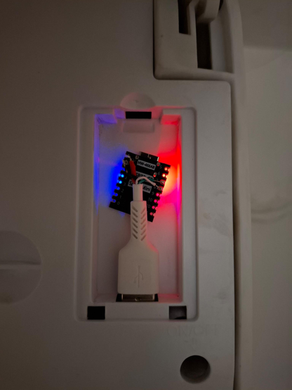 An ESP32C3 microcontroller connected to an AC unit via exposed wires that are coming out of a cut off USB cabel