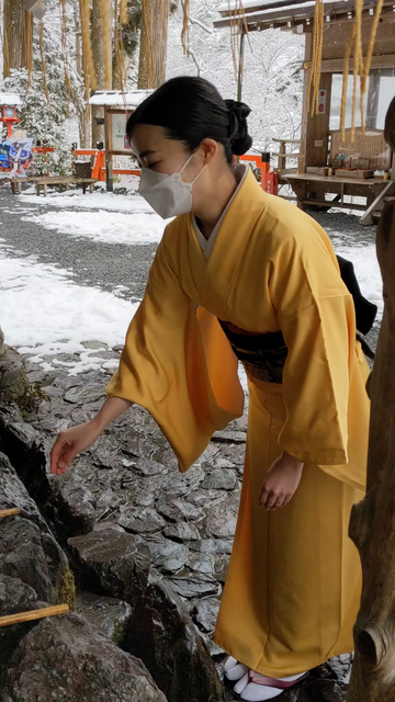 Nao-san purifies herself before praying at Kifune-jinja. She wears a yellow kimono in a nod to the origin of the shrine's name (it is said Tamayori-hime arrived here in a yellow boat).