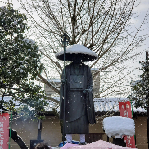 A statue of Kukai at To-ji gathering snow.