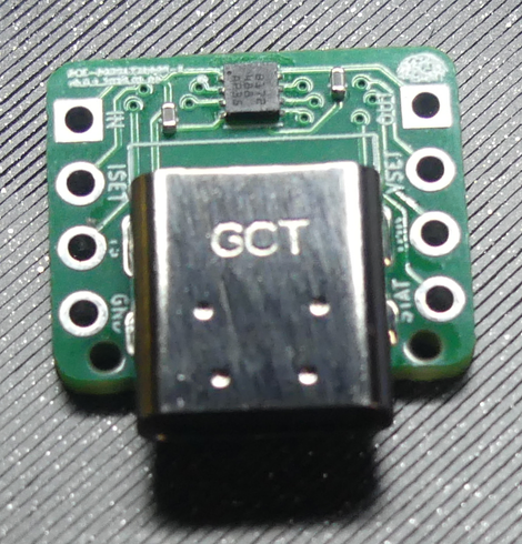 A PCB (Printed Circuit Board) with 4 prototyping holes on the left and 4 on the right.  A female USB-C connector is at the bottom and three chips are across the top.