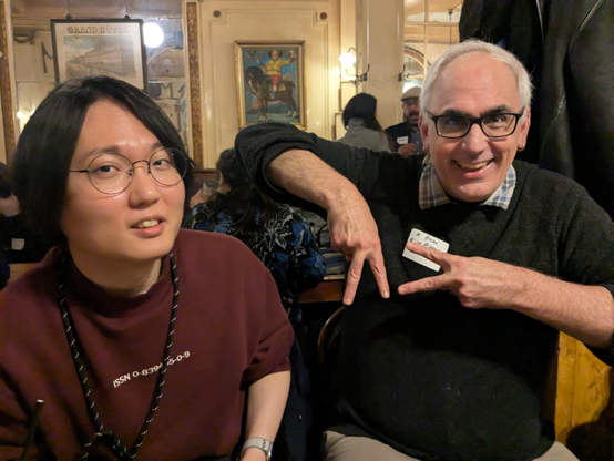 hong minhee in a red shirt and grandfather identica throwing an ap gang sign